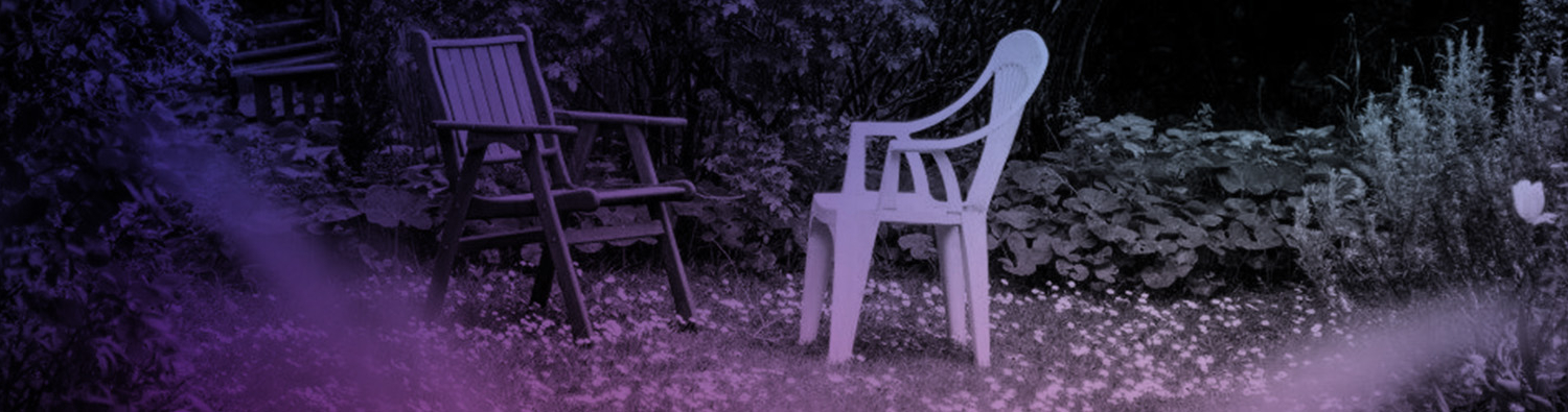 Two garden chairs facing each other in an established garden