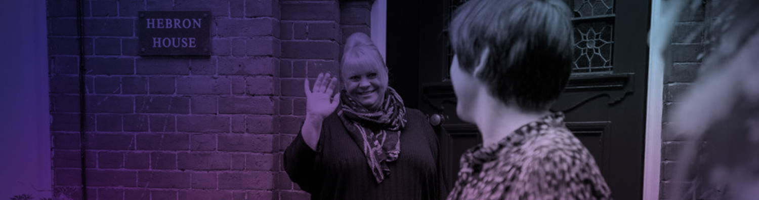 A woman being waved off as leaving a house