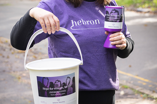 Woman holding collection tins for donations