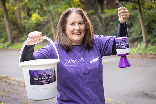 Volunteer holding collection tins